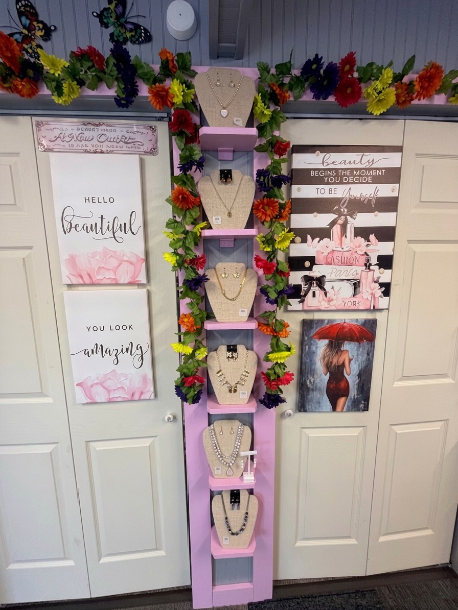 Pink display ladder with necklaces and wall art